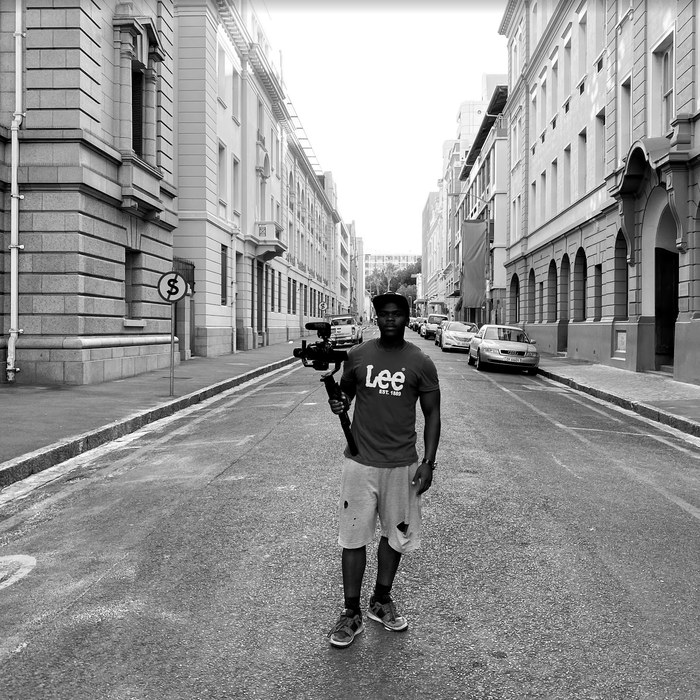 Crew member holding a camera gimbal in a Cape Town street